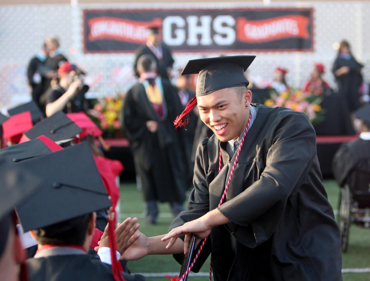 Graduate Eli Pajulas gets some high-fives after getting his diploma at the Glendale High School commencement ceremony at the school in Glendale on Wednesday, June 1, 2016.
