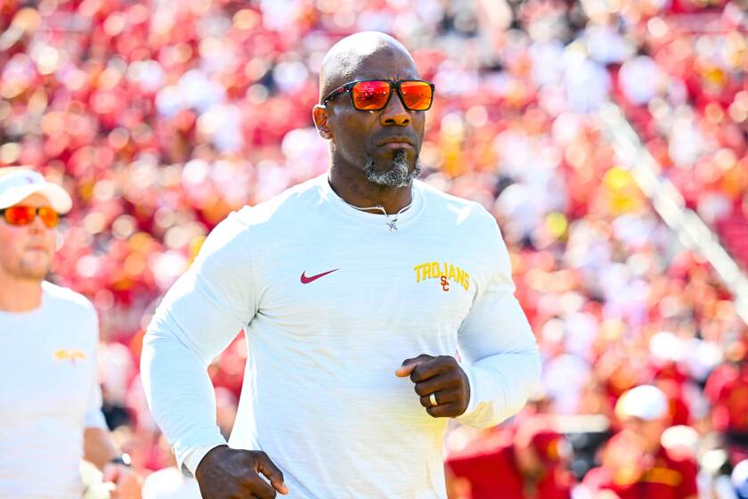 USC strength and conditioning coach Bennie Wylie runs on to the football field.