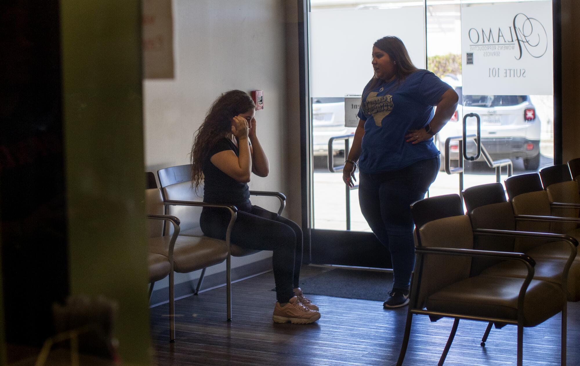 A patient is brought to tears as a staff member informs her that the clinic can no longer provide services