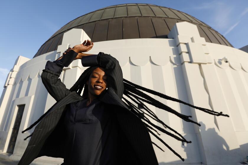 LOS ANGELES, CA - AUGUST 24, 2018 - Musical artist Sudan Archives gets into character as she visits the Griffith Park Observatory in Los Angeles on August 24, 2018. Archives is a rising musical sensation, a violinist and singer who mixes R&B with West Africa and Sudanese rhythms. Her given name is Brittney Parks and she moved to Los Angeles from Cincinnati. Sudan wears an outfit from the Sebastien Ami.Bones Collection. (Genaro Molina/Los Angeles Times)