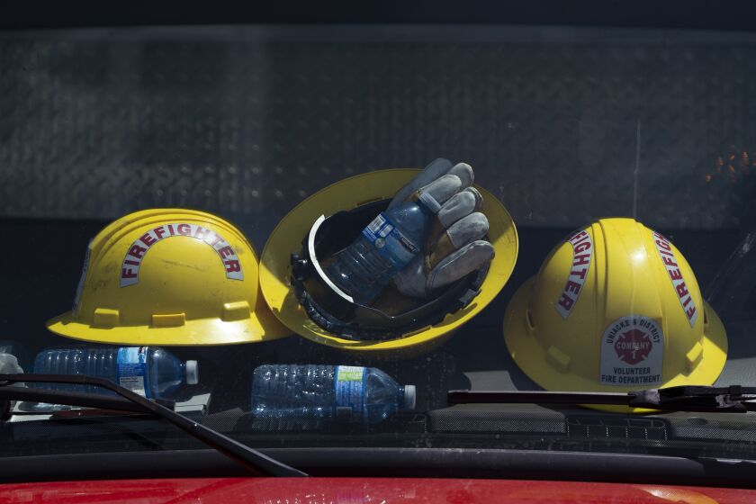 Firefighters' helmets and water bottles rest against the windshield of a truck at a command center within the evacuated zone of the wildfire burning in Tantallon, Nova Scotia, outside of Halifax on Wednesday, May 31, 2023. (Darren Calabrese/The Canadian Press via AP)