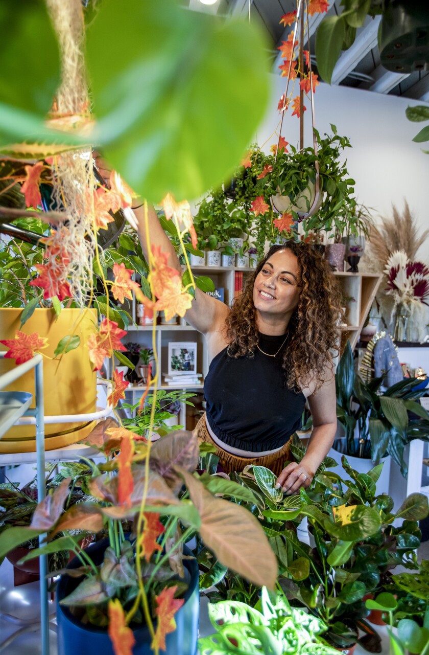 A woman smiles as she tends to the plants.