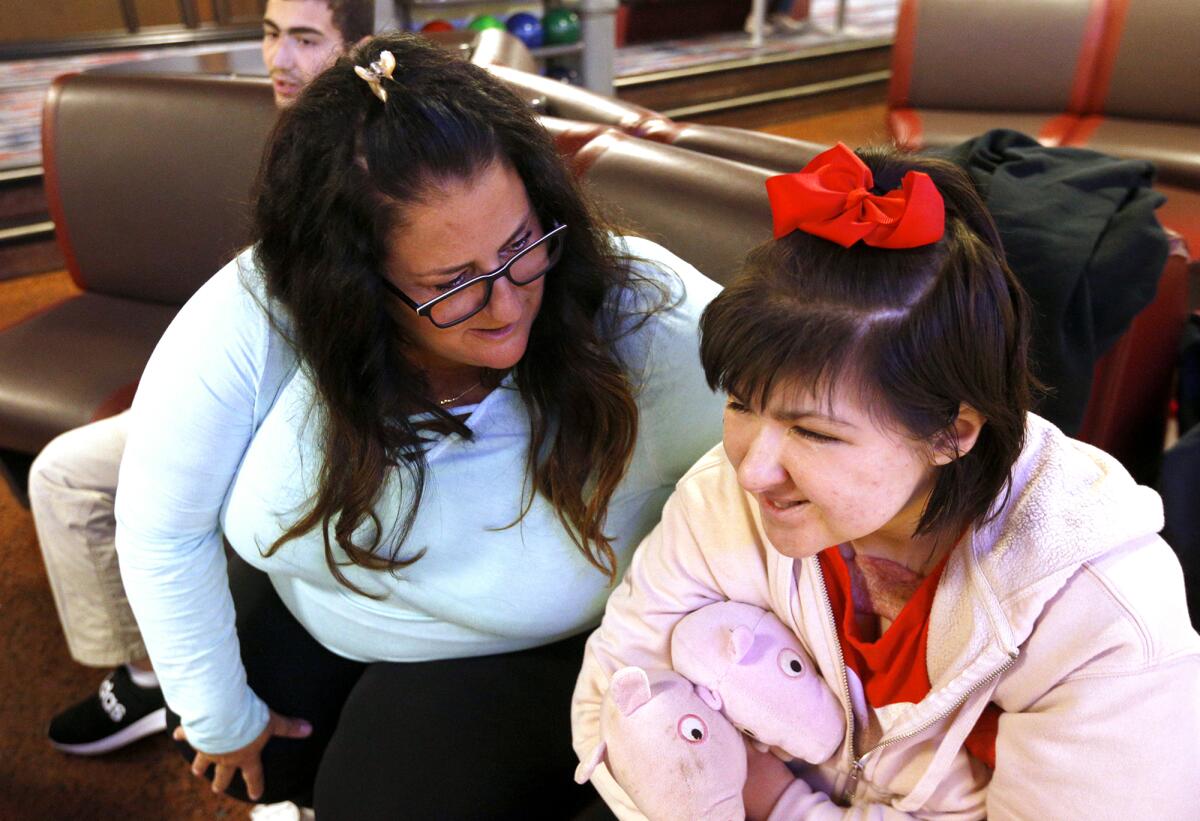 Newport Beach resident Nicole Fusaro chats with Julia Raack during an outing at the Irvine Lanes bowling alley last week.