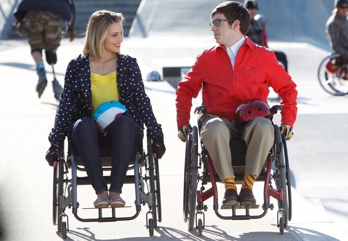 Two actors, a man and a woman, use wheelchairs in an episode of a TV show