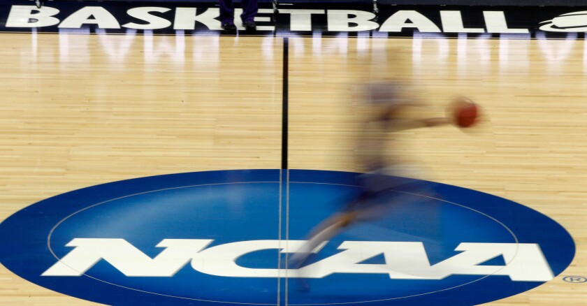 FILE - In this March 14, 2012, file photo, a player runs across the NCAA logo during practice in Pittsburgh before an NCAA tournament college basketball game. The Associated Press has learned that the NCAA has not tested players for performance-enhancing drugs while they’ve been at March Madness and other recent college championships. Three people familiar with testing protocols tell AP full-scale testing has not resumed since the coronavirus pandemic shut down college sports a year ago. (AP Photo/Keith Srakocic, File)