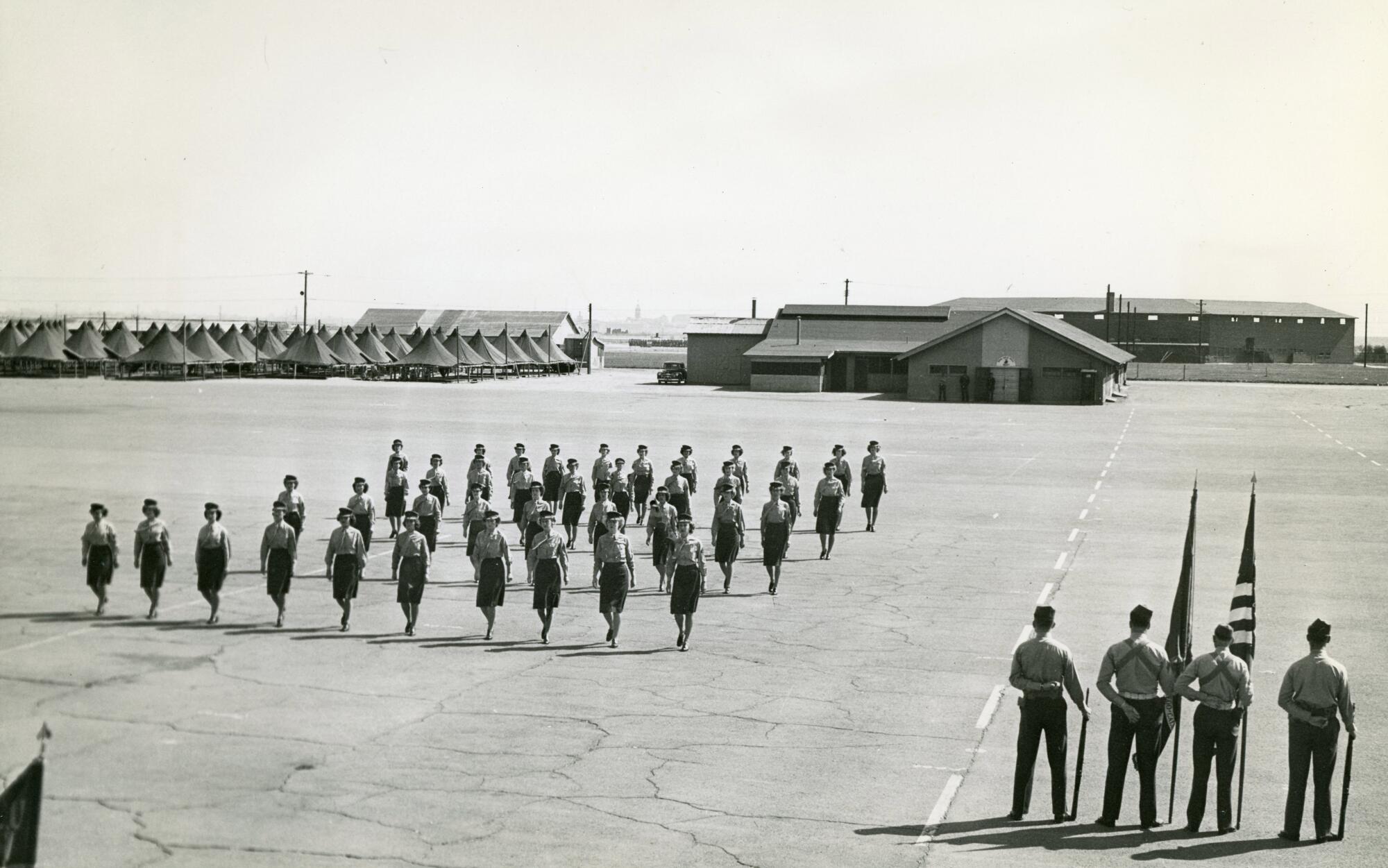 Female Marines march in formation on the parade ground at the Marine Corps Recruit Depot