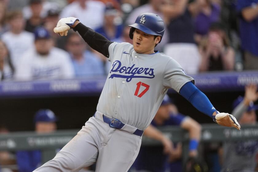 Los Angeles Dodgers' Shohei Ohtani scores on a triple hit by Will Smith off Colorado Rockies.