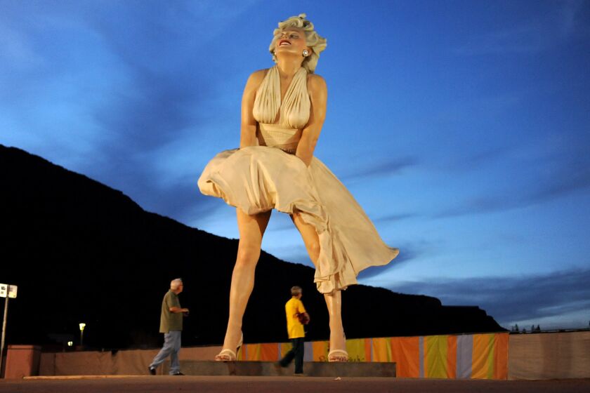 A couple walks past a 26-foot statue of Marilyn Monroe in Palm Springs.