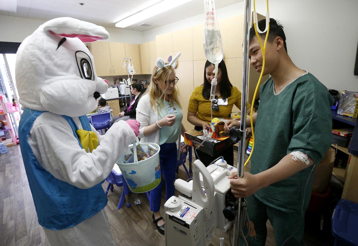 The Easter Bunny gives Fountain Valley regional patient Nguyen Phan some chocolate eggs during a special visit Friday.