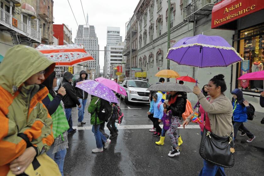 Pedestrians take cover in the Chinatown district of San Francisco as a powerful storm rolled into the Bay Area.