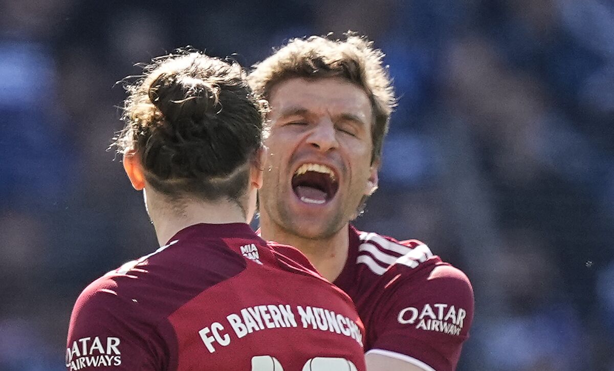 Bayern's Thomas Mueller, right, celebrates with Bayern's Marcel Sabitzer,left, after Arminia's Jacob Barrett Laursen scored an own goal during the German Bundesliga soccer match between Arminia Bielefeld and Bayern Munich in Bielefeld, Germany, Sunday, April 17, 2022. (AP Photo/Martin Meissner)