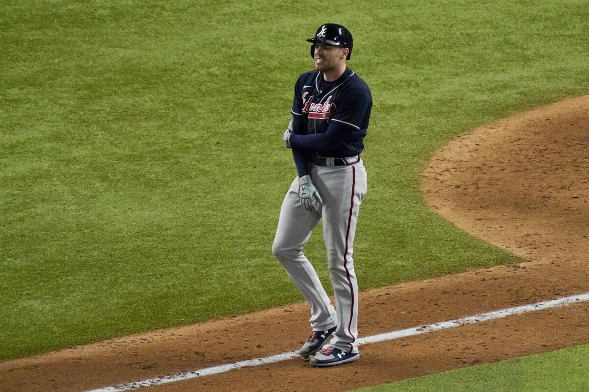 Atlanta's Freddie Freeman holds his arm after getting hit by a pitch against the Dodgers.