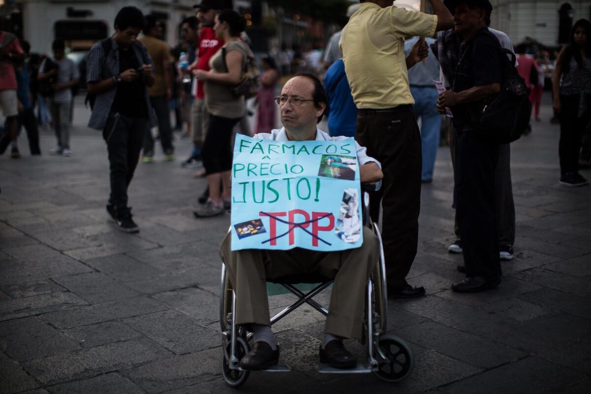 A demonstrator in a wheelchair holds a banner reading 'Drugs at a Fair Price' during an anti-TPP rally in Lima, Peru on Feb 4.
