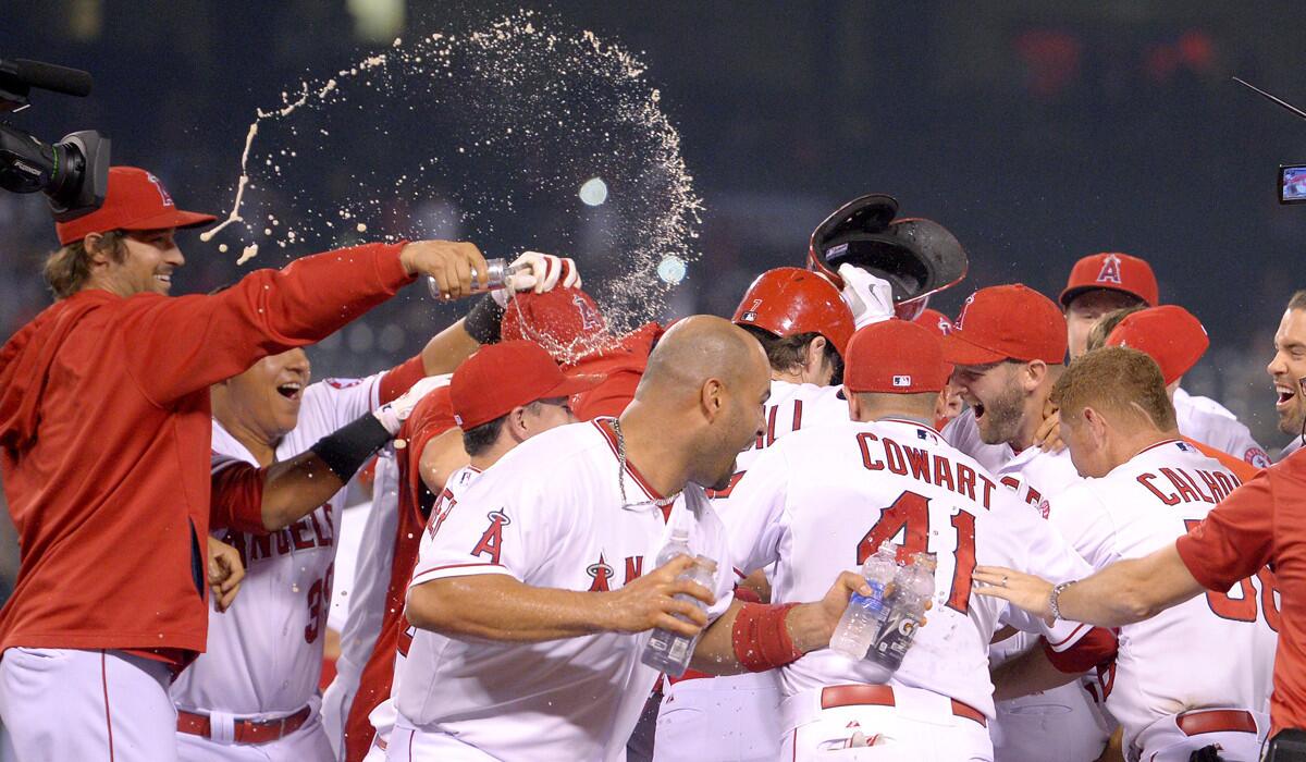 Players surround Angels' David Murphy after hitting a walk-off single to win in the ninth inning against the Oakland Athletics on Monday.