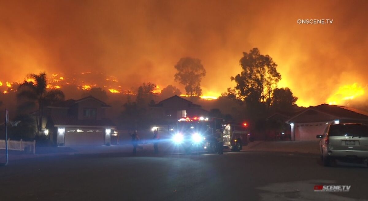 Flames burn a hillside Wednesday in Rancho San Diego e.