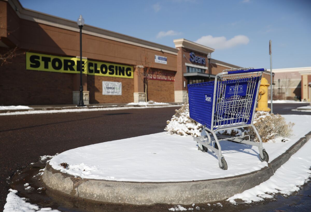 An empty shopping cart sits in the snow outside a now-closed Sears store in Littleton, Colo., on Jan. 1.