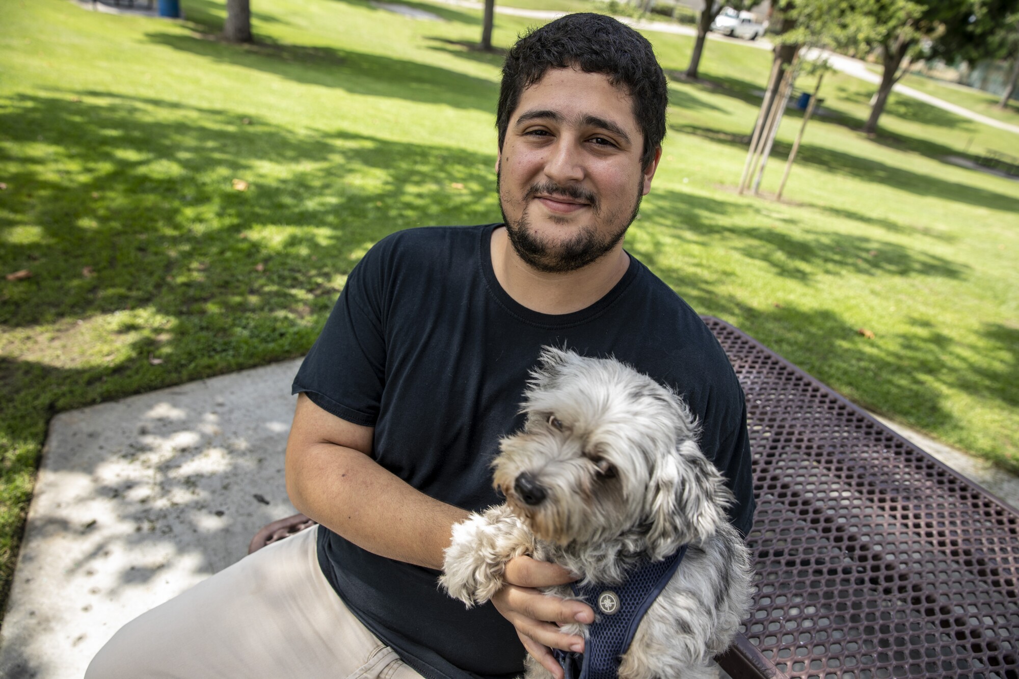 Cudahy resident Ulysses Sandoval, 25, pauses on a walk with his dog Chia, in a park near his home.