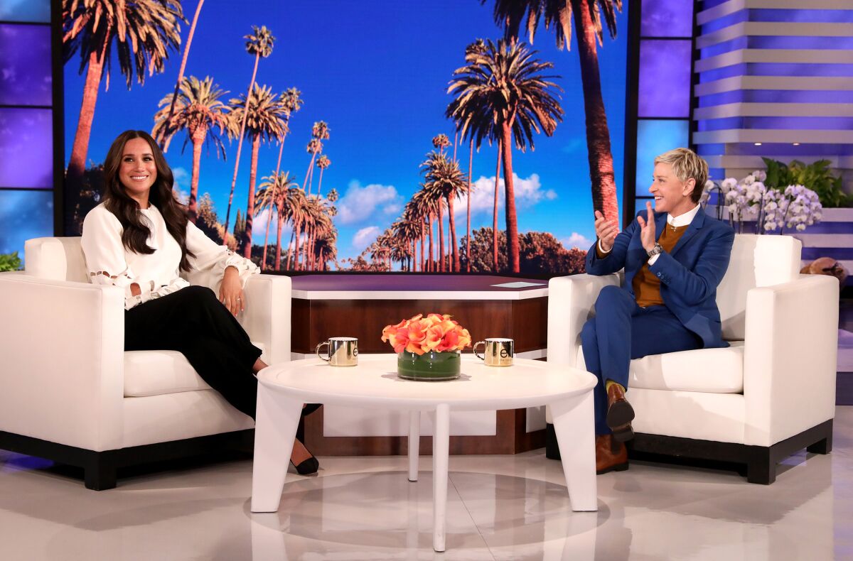Two women sitting in armchairs on stage