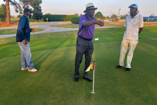 Caddies Tommy Bennett (in white), Buck Moore (dark blue), and Jariah Beard (purple)  at Augusta Municipal Golf Course.