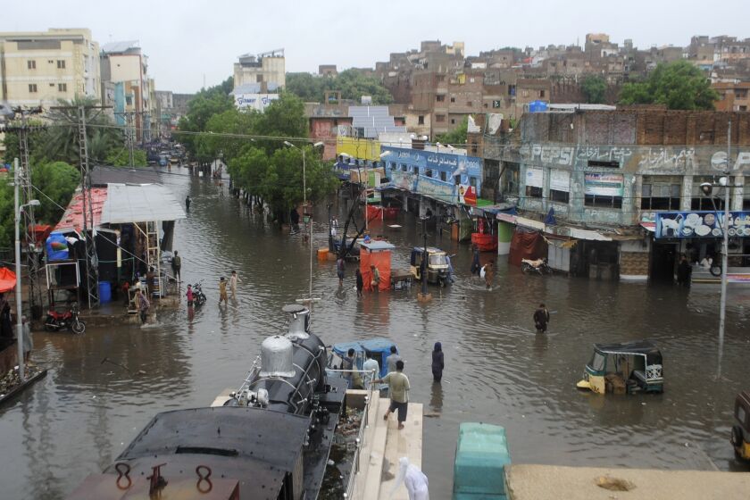 People navigate through flooded roads after heavy monsoon rains, in Hyderabad, Pakistan, Wednesday, Aug. 24, 2022. Heavy rains have triggered flash floods and wreaked havoc across much of Pakistan since mid-June, leaving 903 dead and about 50,000 people homeless, the country's disaster agency said Wednesday. (AP Photo/Pervez Masih)