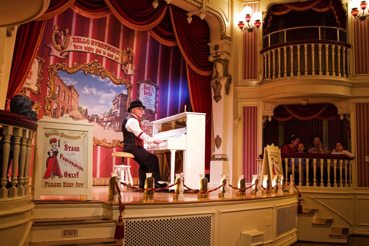 A ragtime pianist sits at his white piano onstage at the Golden Horseshoe.