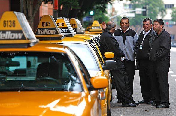 Taxis and drivers wait in front of the Omni Hotel for fares Monday afternoon. The city of Los Angeles' new Hail-A-Taxi program aims to promote the use of taxis in downtown Los Angeles. The campaign will inform downtown residents, office workers and visitors that they can use taxis any time and anywhere (except bus zones), especially during the busy holiday season.