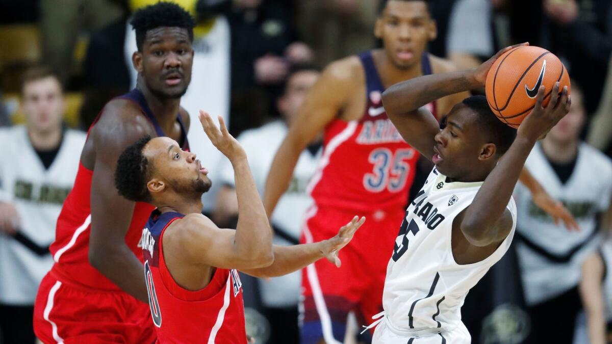 Colorado guard McKinley Wright IV (right) looks to pass the ball as Arizona guard Parker Jackson-Cartwright defends in the first half.