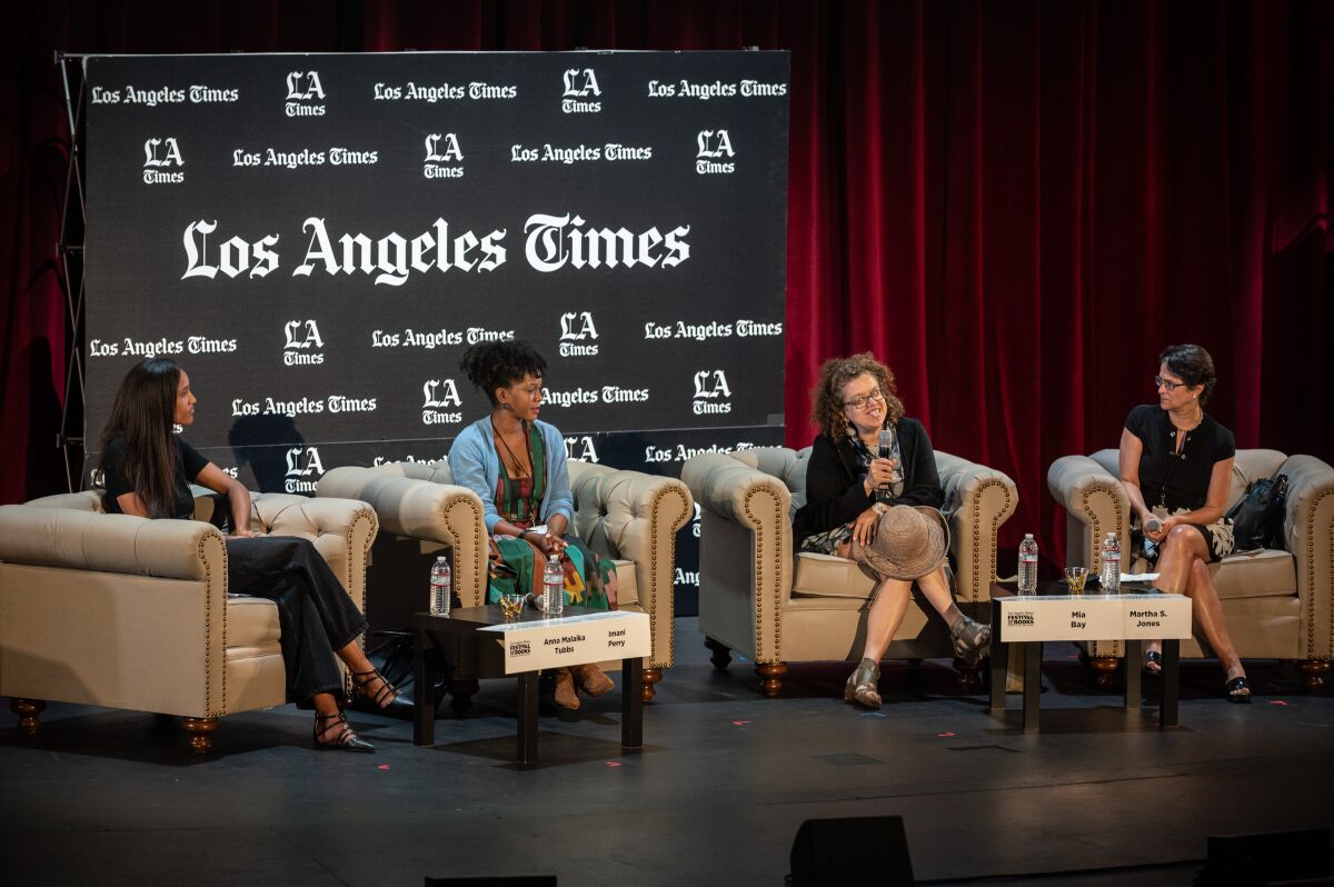 Mia Bay holds a microphone as she speaks on a panel with Anna Malaika Tubbs, Imani Perry and Martha S. Jones.