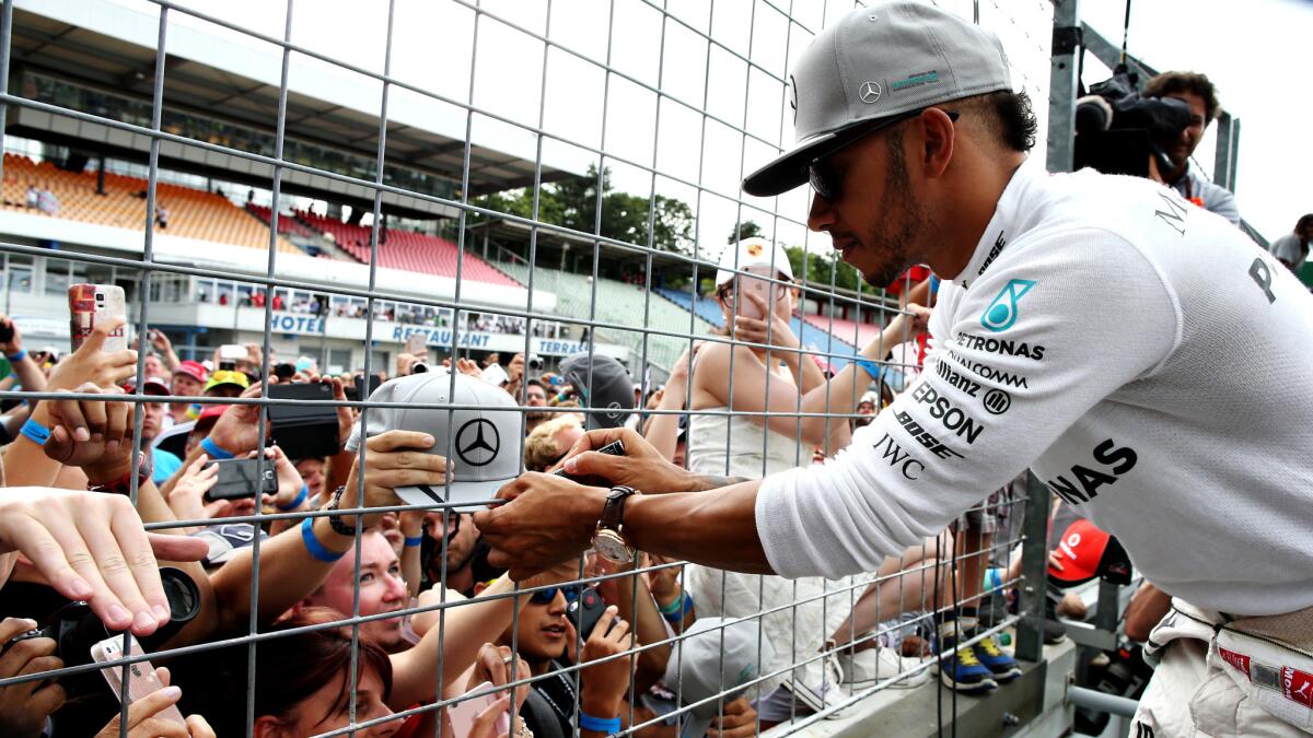 Formula One driver Lewis Hamilton signs autographs after winning the German Grand Prix on Sunday.