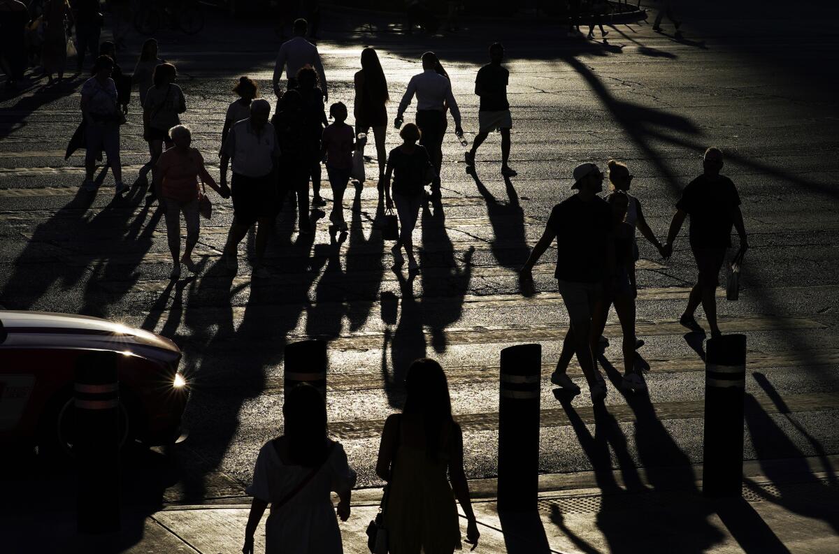 Personas cruzan el bulevar Las Vegas el viernes 2 de julio de 2021 en Las Vegas. (AP Foto/John Locher)