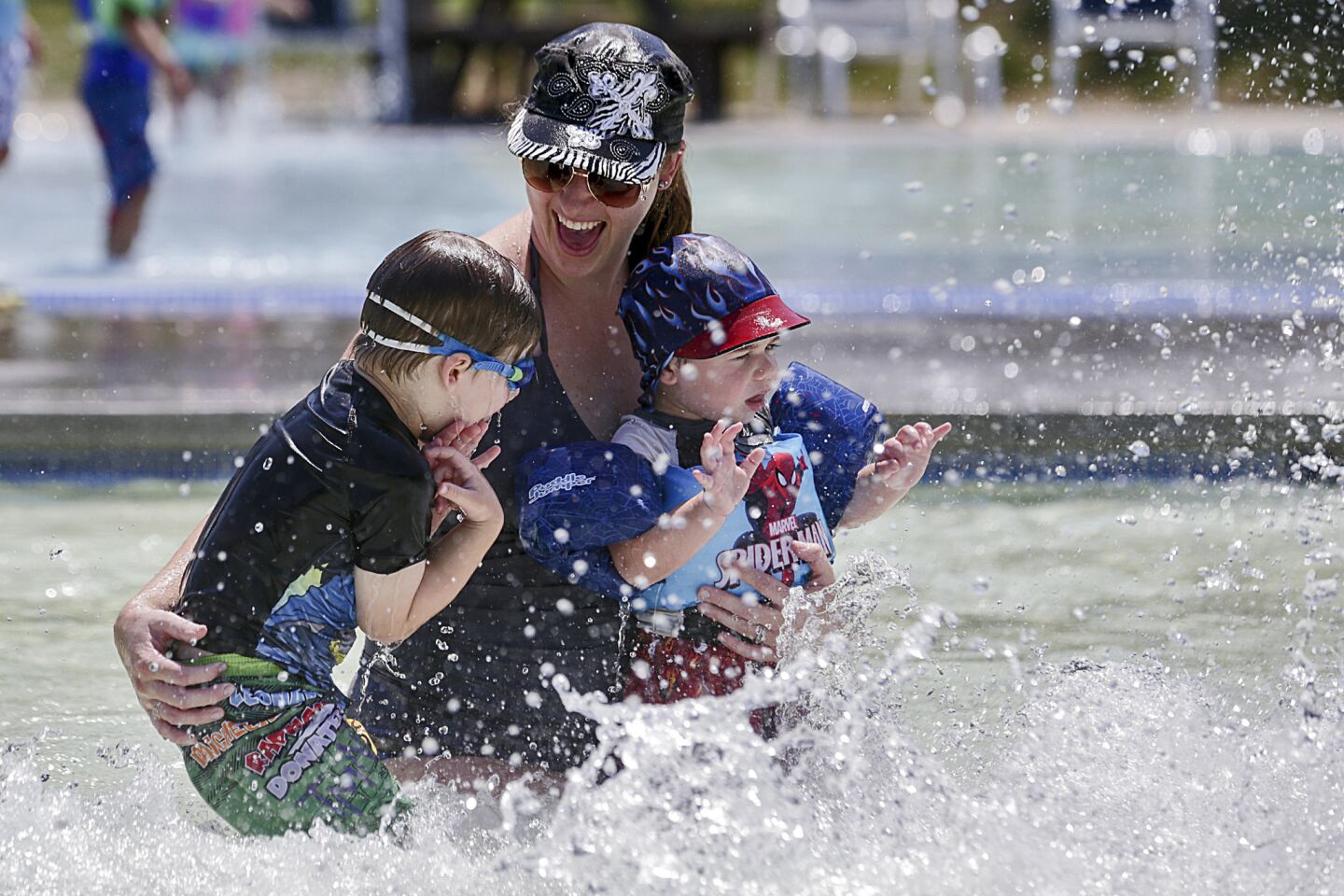 Tawny Auer joins her sons Shane, left, and Carter to cool off in a pool at the aquatic center in Palm Desert, where temperature reached 115 degrees.