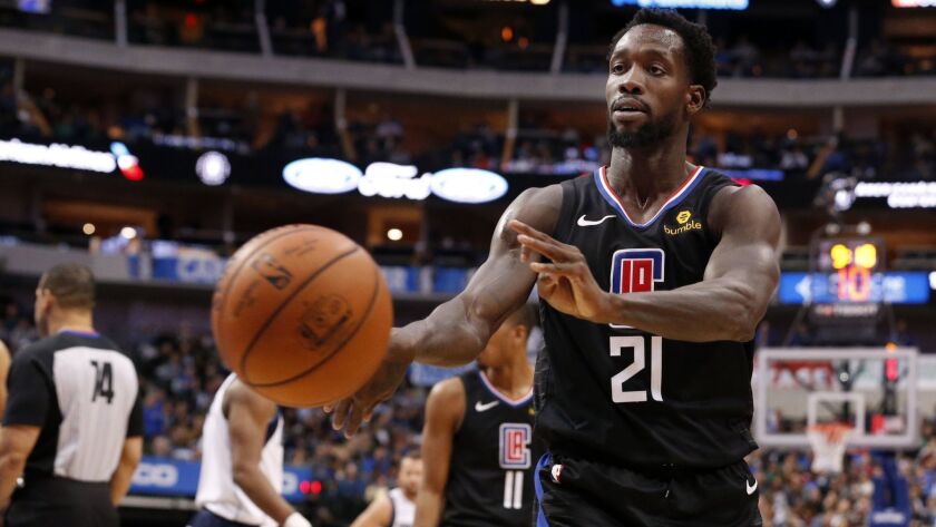 Clippers guard Patrick Beverley throws a bounce pass toward a fan during the fourth quarter of a game in Dallas on Sunday.