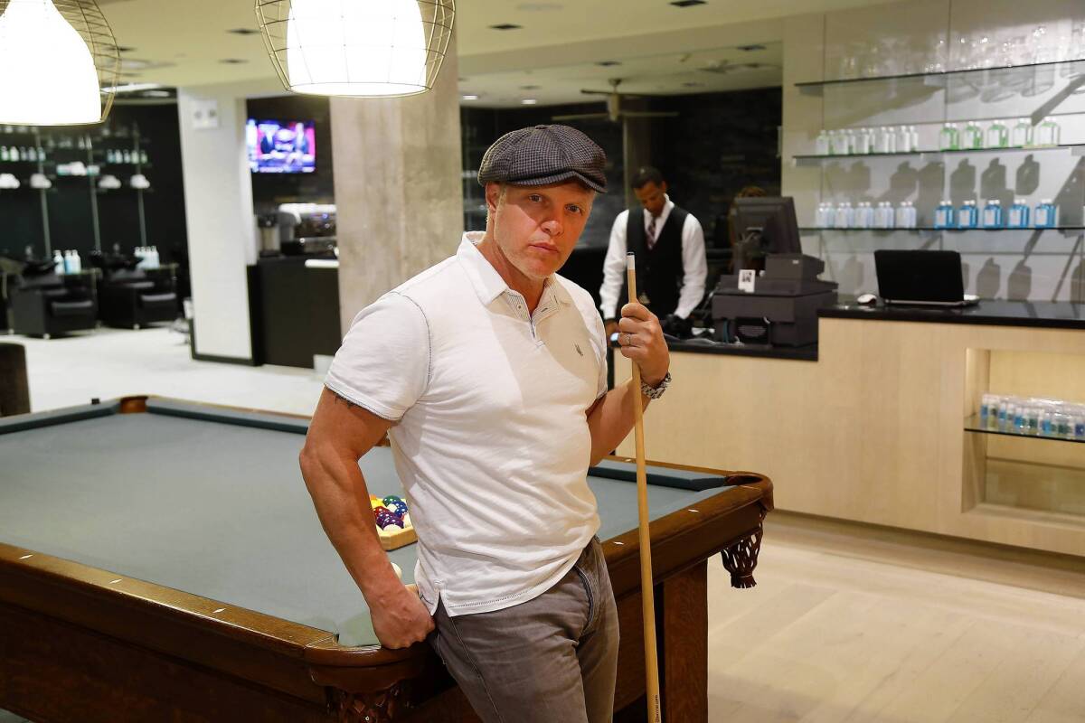 John Allan plays a round of billiards at his eponymous grooming shop at the Beverly Hills Saks Fifth Avenue, which features an optional membership program.