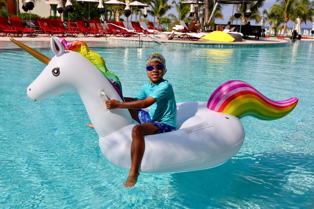 Zephyr Martell rides a unicorn float in a pool in the Cayman Islands in 2019.