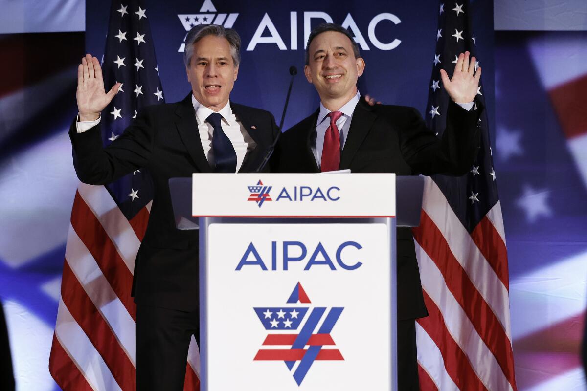 Michael Tuchin, right, and Antony J. Blinken at an AIPAC lectern.