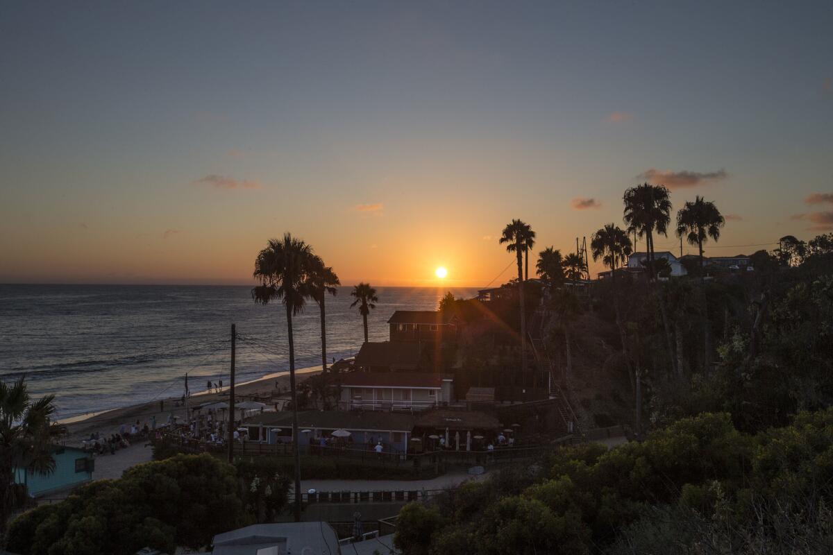 The sun sets over the Crystal Cove Beach Cottages in Newport Beach in 2016. A spill of about 1.4 million gallons of raw sewage prompted beach closures in Orange County.