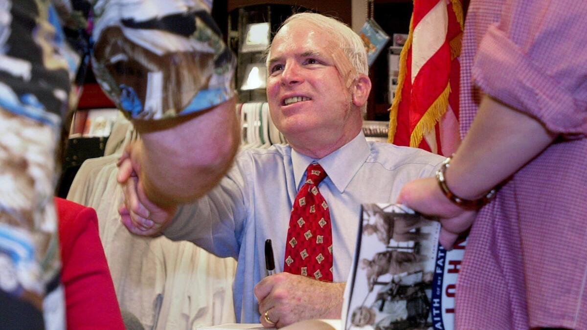 John McCain shakes hands while signing copies of his book "Faith of My Fathers" in Pasadena in September 2000.