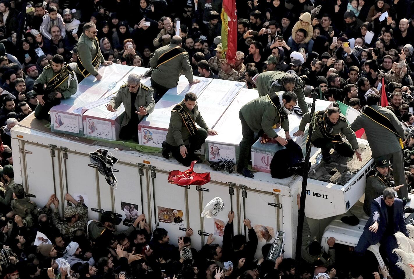 Coffins of Gen. Qassem Soleimani and others who were killed in Iraq by a U.S. drone strike, are carried on a truck surrounded by mourners during a funeral procession at the Enqelab-e-Eslami (Islamic Revolution) square in Tehran, Iran, Monday, Jan. 6, 2020. The processions mark the first time Iran honored a single man with a multi-city ceremony. Not even Ayatollah Ruhollah Khomeini, who founded the Islamic Republic, received such a processional with his death in 1989. Soleimani on Monday will lie in state at Tehran's famed Musalla mosque as the revolutionary leader did before him. (AP Photo/Ebrahim Noroozi)