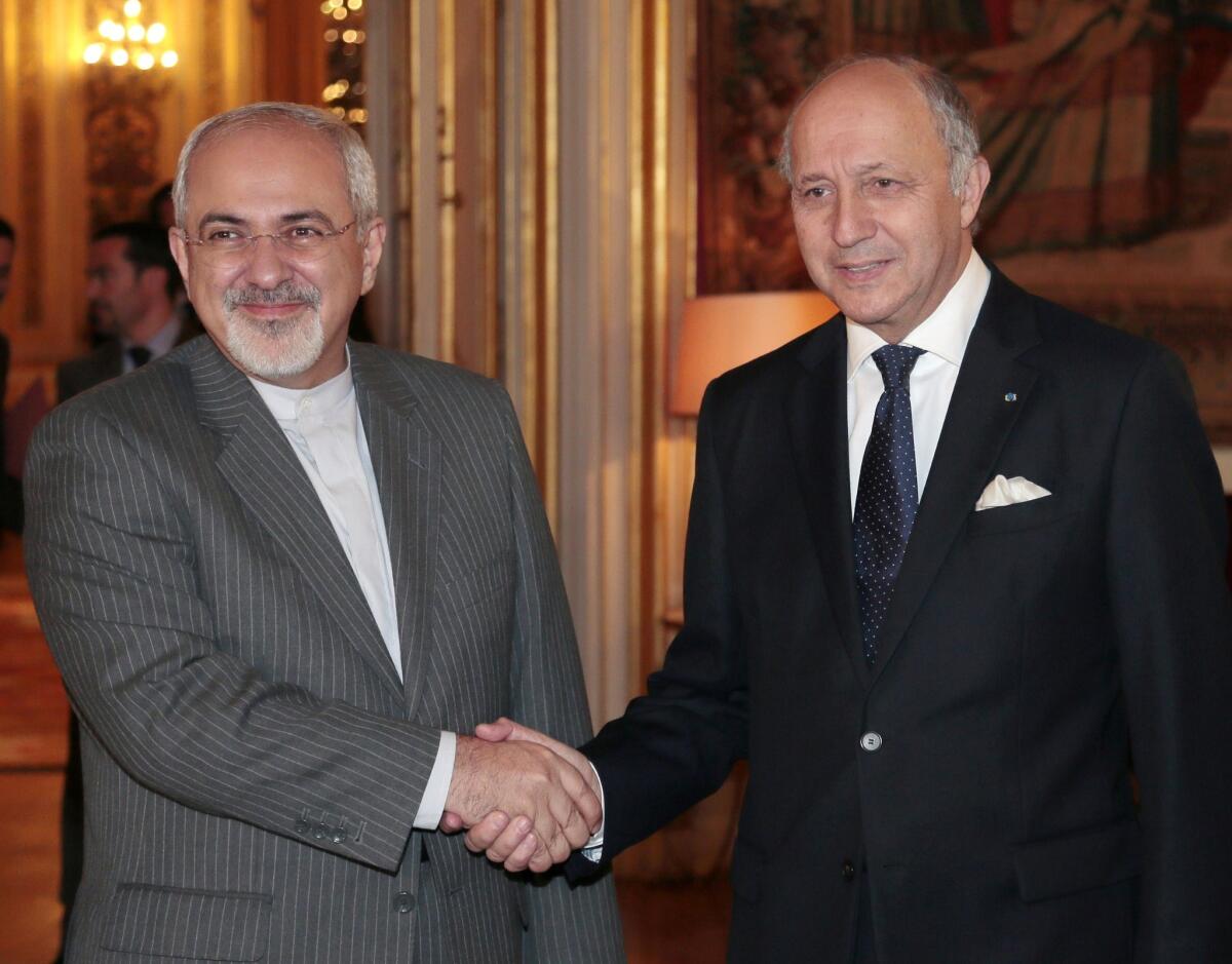 French Foreign Minister Laurent Fabius, right, welcomes Iranian Foreign Minister Mohammad Javad Zarif in Paris. Zarif will take part in talks in Geneva this week with representatives of six world powers, which are seeking curbs on Iran's nuclear program.