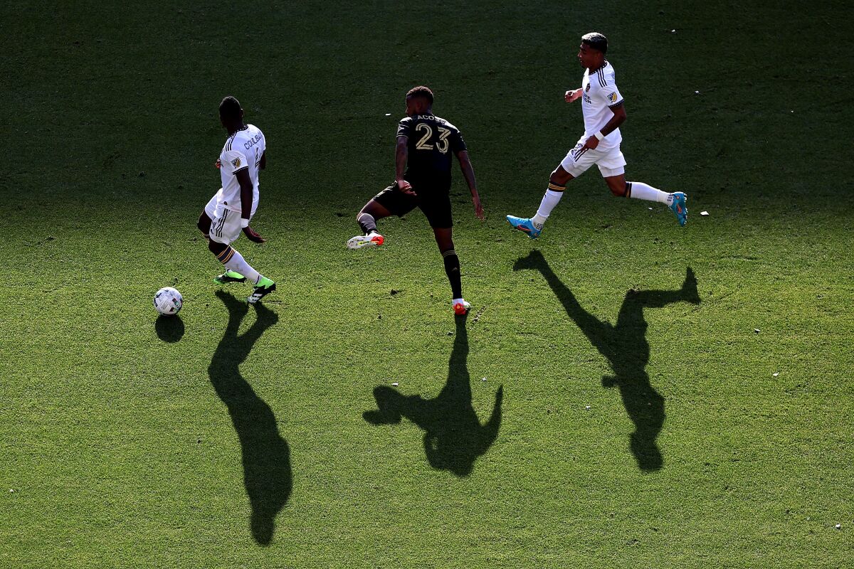 The Galaxy's Sega Coulibaly, left, and Julian Araujo, right, control the ball against LAFC's Kellyn Acosta in the first half.