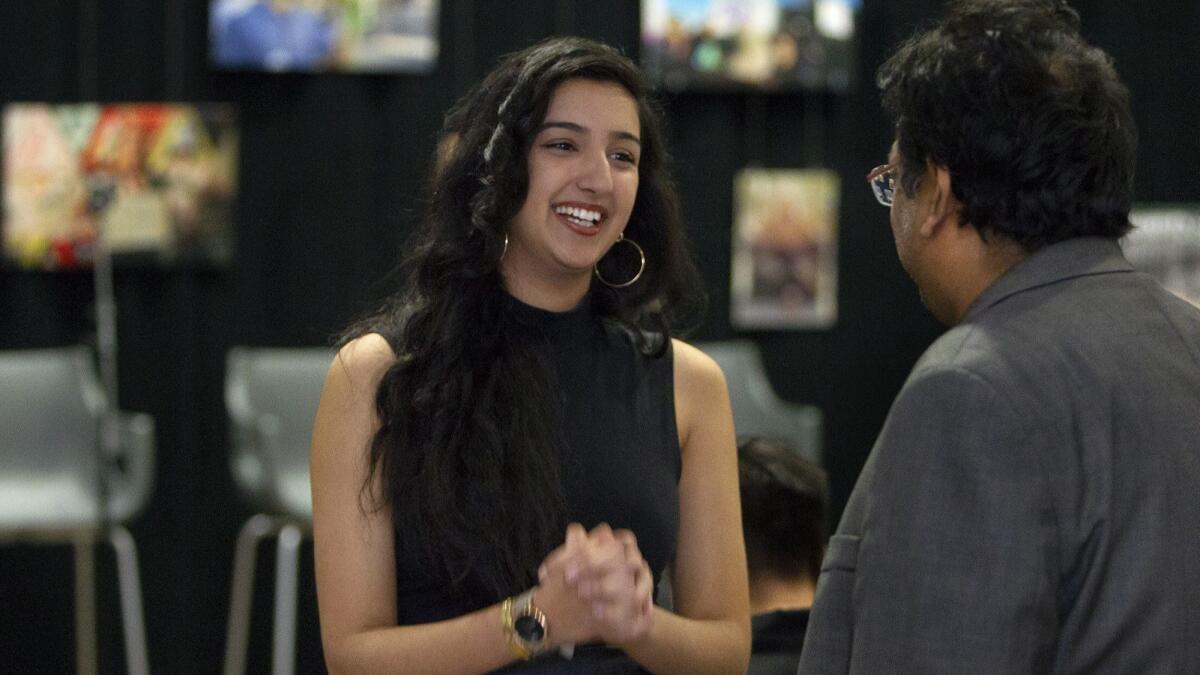 Aditi Mayer, founder and editor-in-chief of Insight Magazine, speaks to a guest during a reception for the inaugural edition's launch at Viewpoint Gallery in the UC Irvine Student Center on April 24.