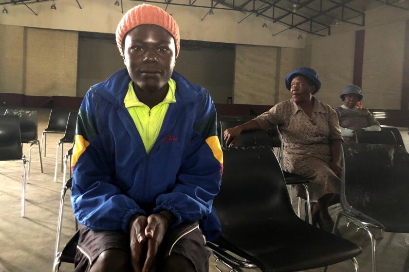 James Mashakeni, left, and Grace Pitse, middle, attend a meeting in a community hall in Brits, South Africa, about drug addiction.