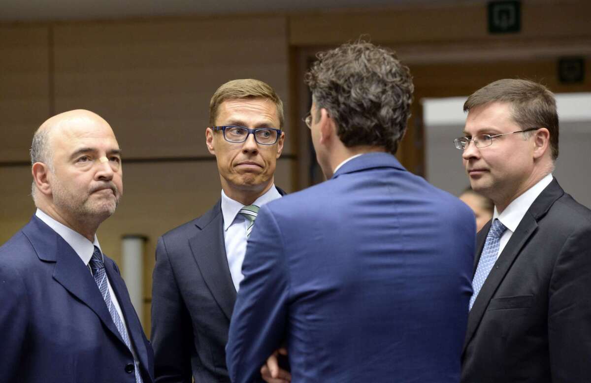 EU Commissioner for Economic and Financial Affairs Pierre Moscovici, left, Finnish Finance Minister Alexander Stubb and EU Commissioner for the Euro Valdis Dombrovskis talk with Eurogroup President Jeroen Dijsselbloem, back to camera, Saturday in Brussels.