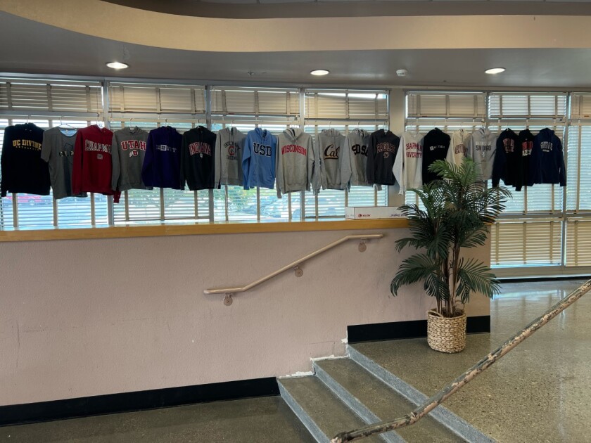 A display of sweatshirts representing some of the universities the honorees will attend in fall 2022.