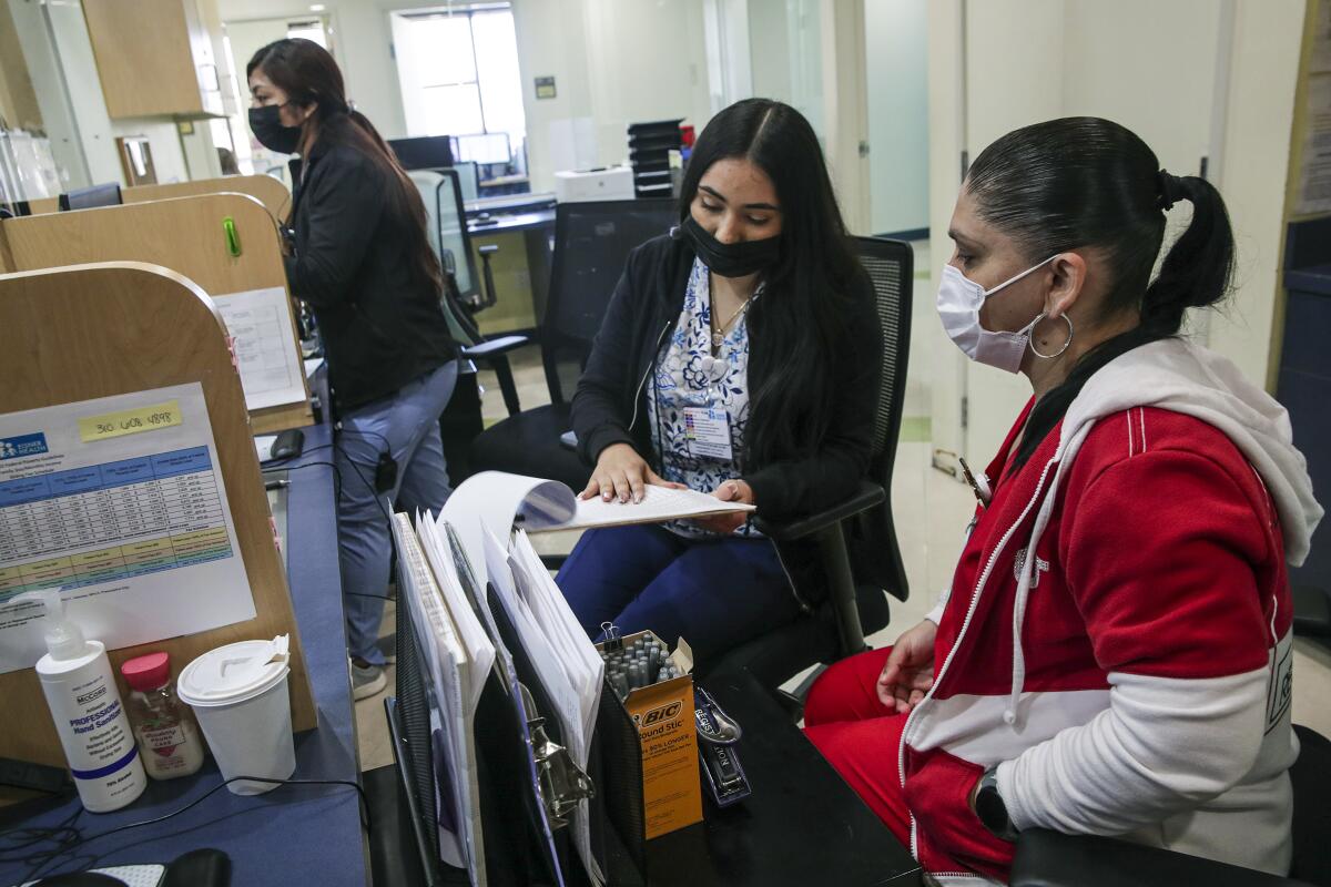 Rosa Mireles, right, trains new employee Janette Garcia at Eisner Health Clinic