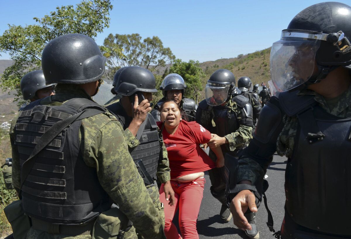 La policía militar del ejército mexicano detiene a una mujer, el viernes 6 de febrero de 2015