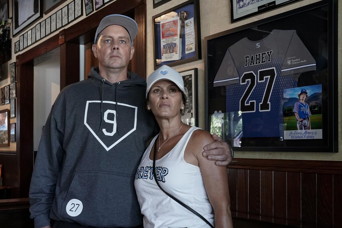 Padrig and Gina Fahey stand next to a tribute to their son, Braden. 