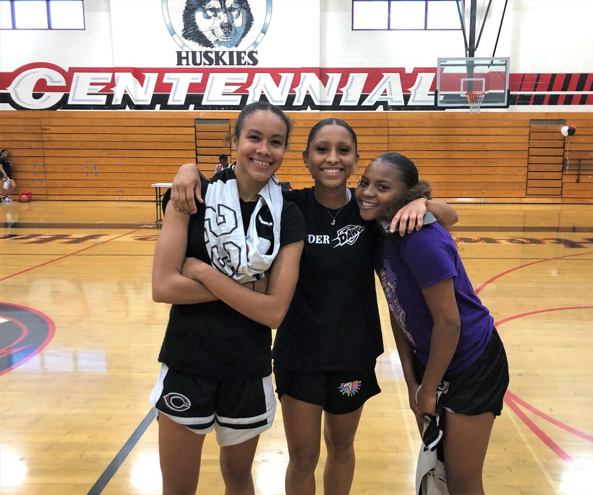 Corona Centennial girls' basketball team captains Trinity San Antonio, Jayda Curry, and Londynn Jones gather for a photo.