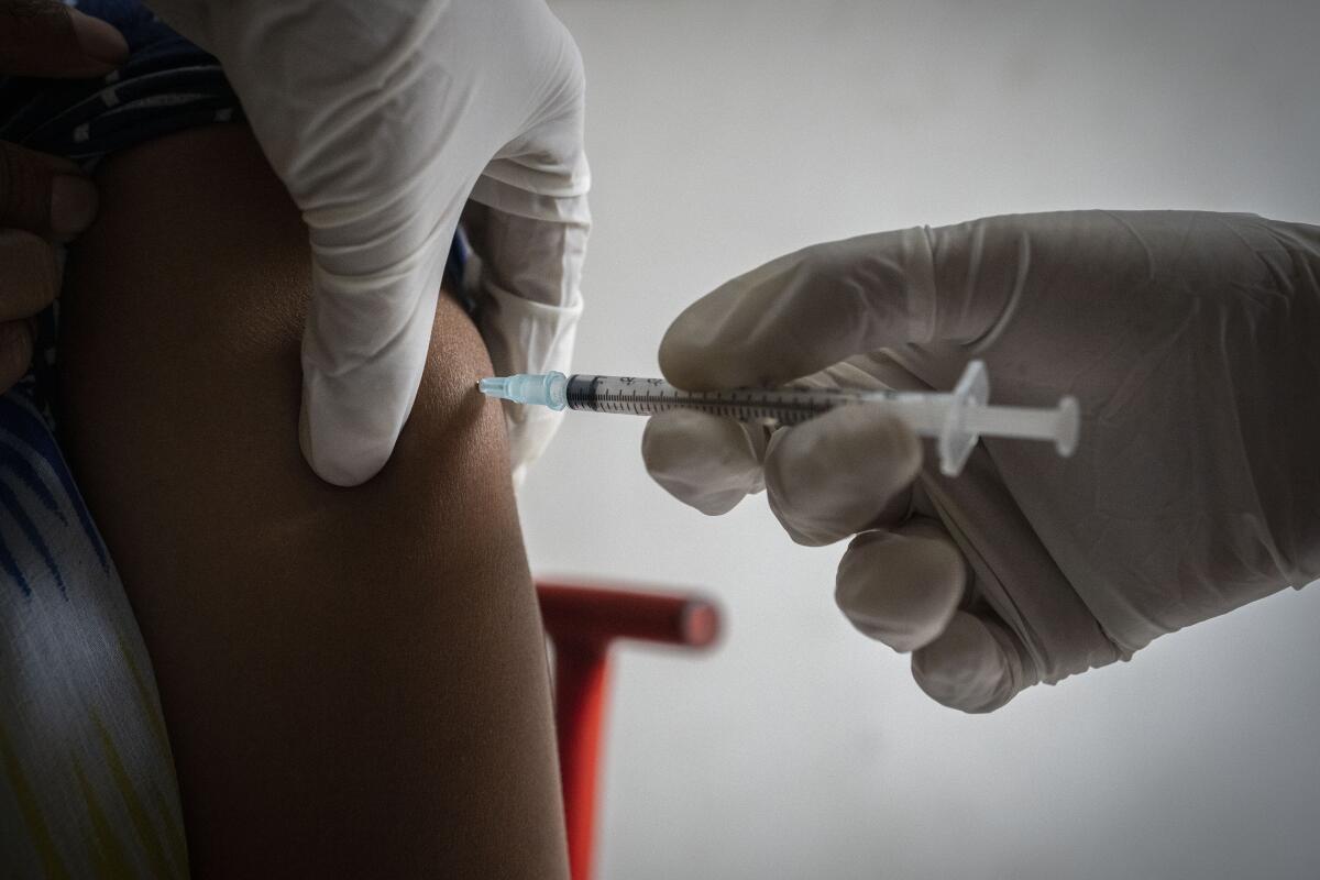 Una mujer recibe la tercera dosis de la vacuna contra el COVID-19 en un centro de vacunación privado 