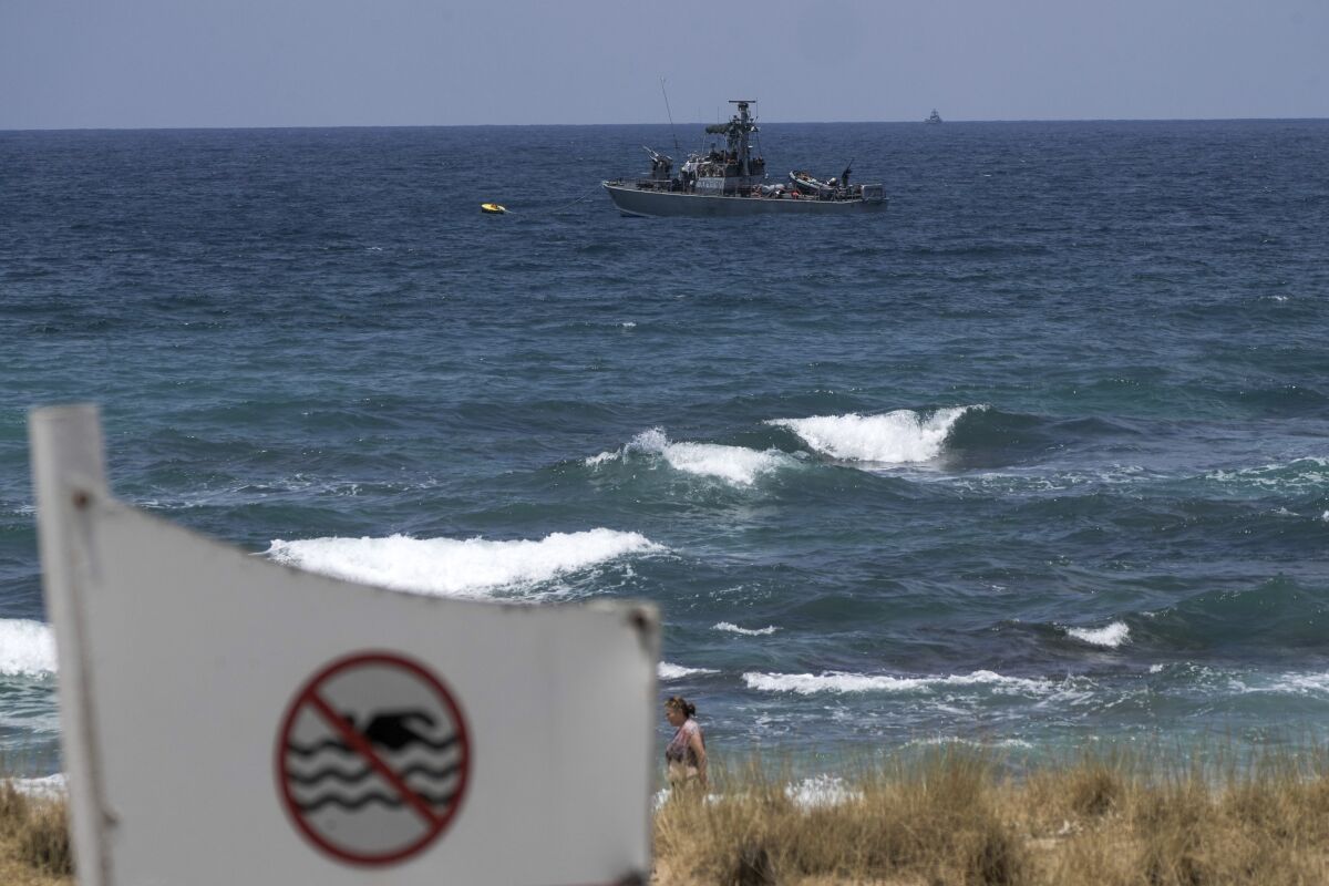 FILE - An Israeli Navy vessel anchored in the Mediterranean Sea is seen from the Rosh Hanikra border crossing between Israel and Lebanon in northern Israel, July 3, 2022. The Israeli prime minister warned Lebanon on Tuesday, July 19, 2022, that any escalation on its northern border would be met with a harsh military response a day after the Israeli military said it intercepted a drone that crossed from Lebanese territory. (AP Photo/Ariel Schalit, File)